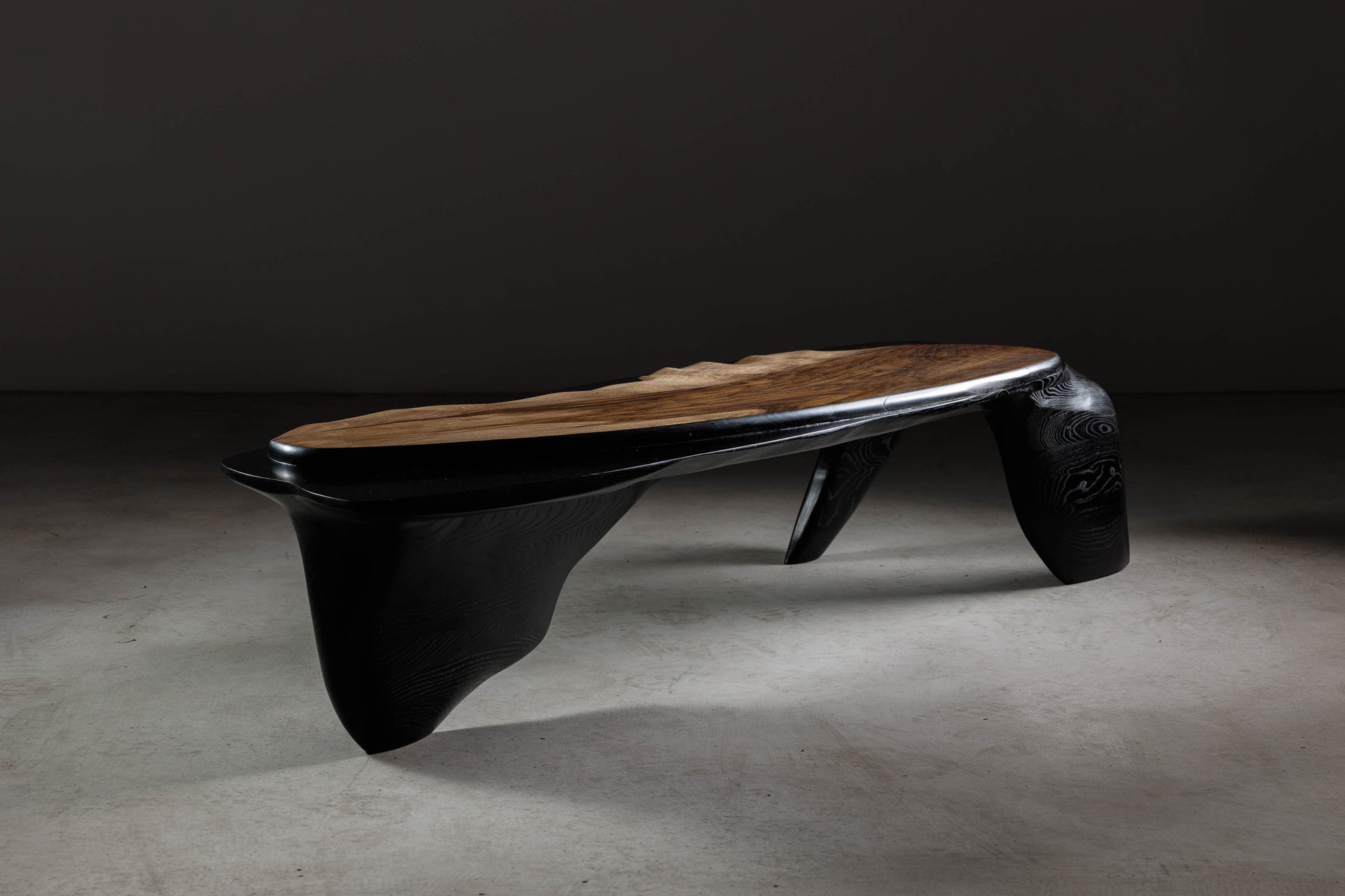 Sculptural Walnut Coffee Table EM110 Part Of Erosio Collection | Perspective image showing the fluid lines of this unique coffee table.